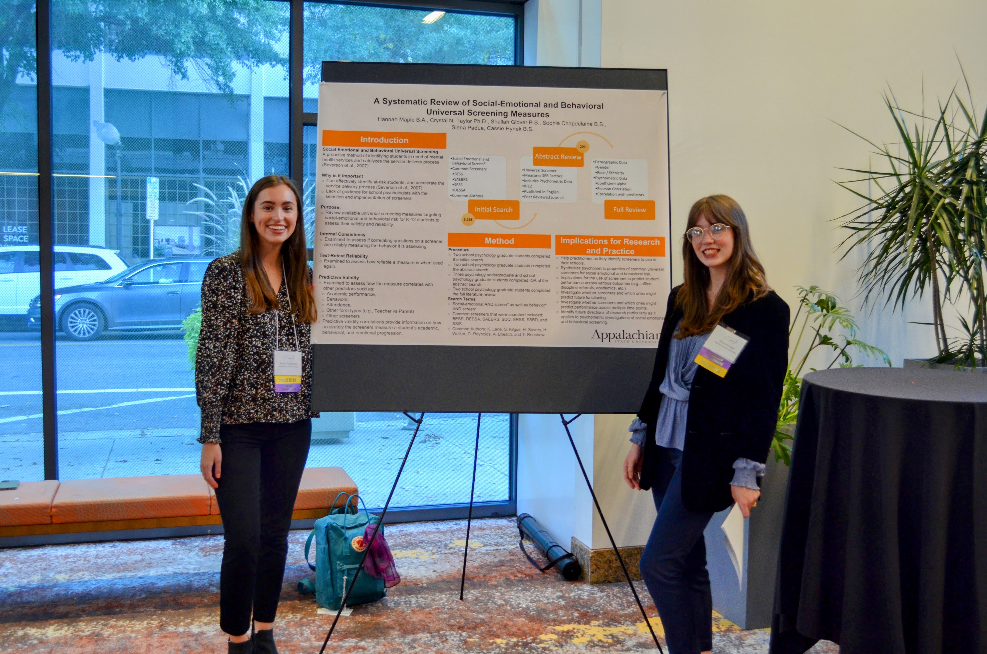 Two people presenting an academic poster